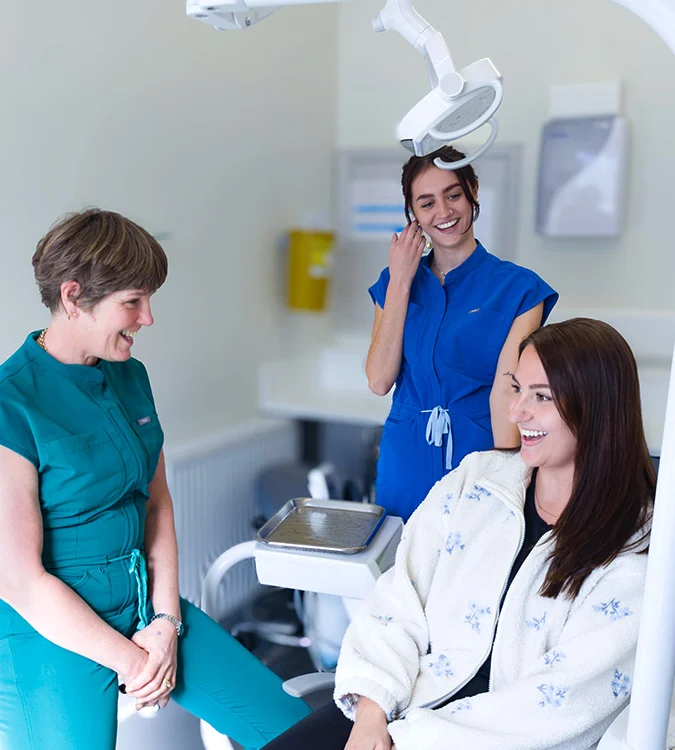 Anaesthetist and dental nurse talking with a relaxed patient in the chair