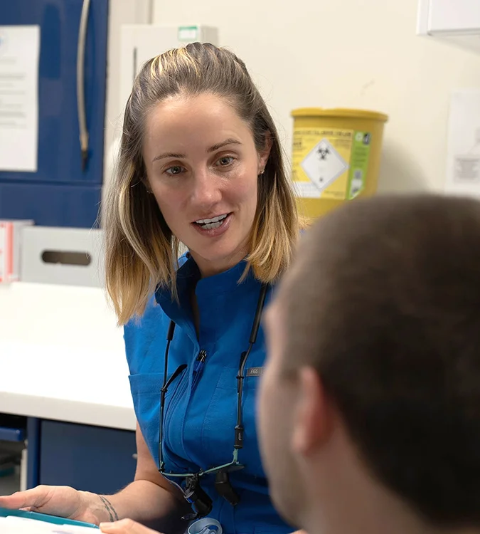 Dentist smiling while talking with a patient