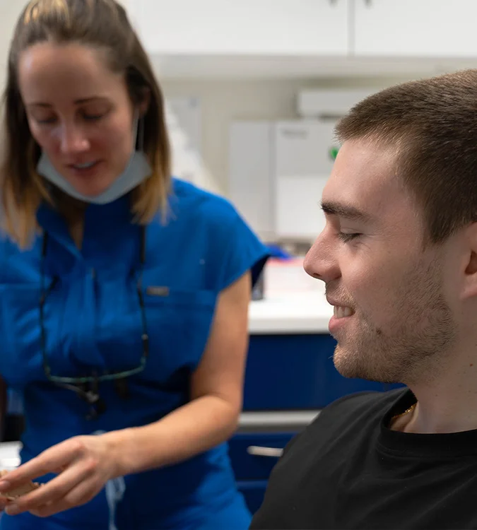 Dental clinician smiling and chatting with a patient