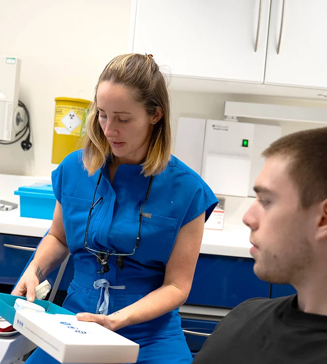 Clinician showing a patient an Invisalign aligner pack
