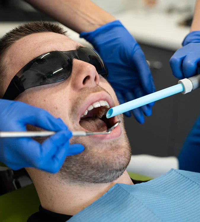 Smiling patient in protective glasses during a dental check-up