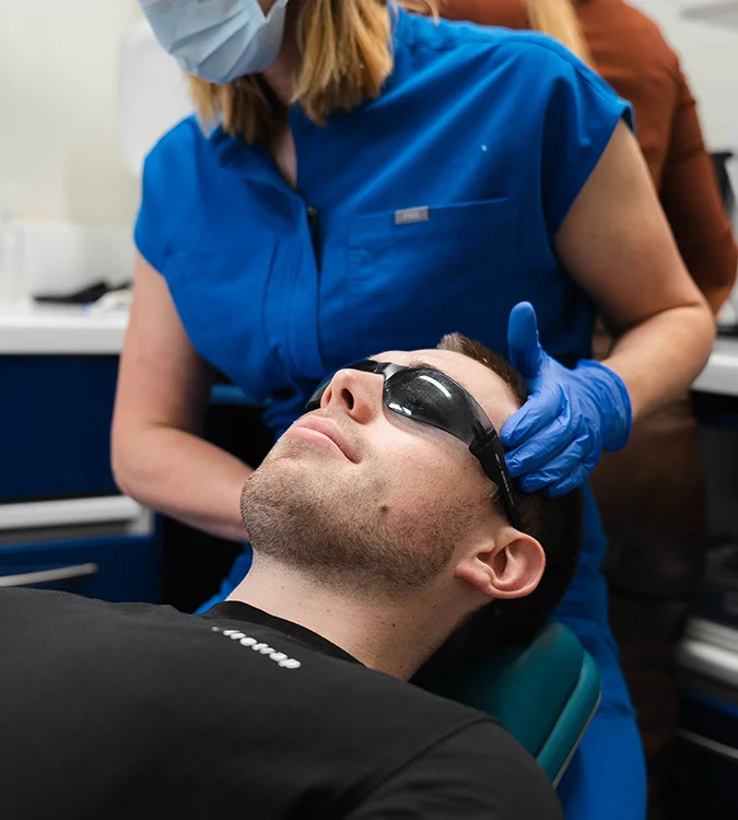 Dental nurse supporting a patient’s jaw during a TMJ assessment